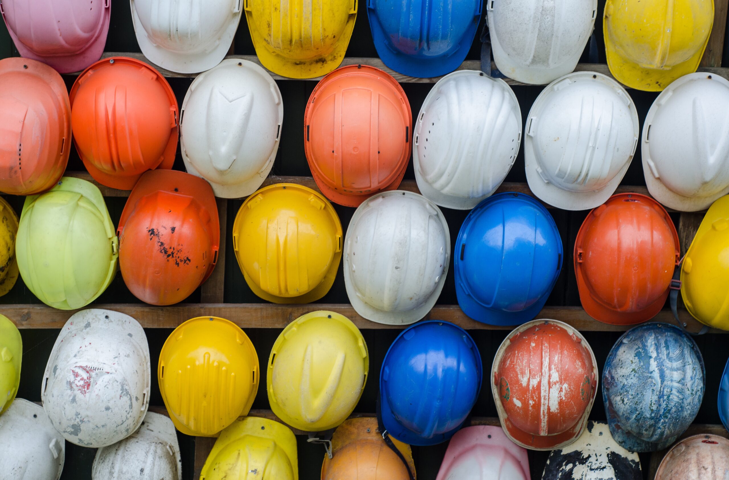 a wall of multicolored hard hats